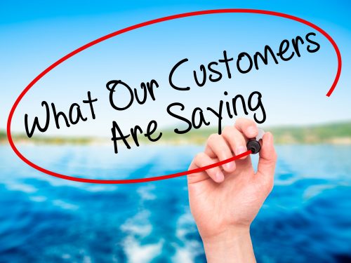 Man Hand writing What Our Customers Are Saying with black marker Man Hand writing What Our Customers Are Saying with black marker on visual screen. Isolated on nature. Business, technology, internet concept. Stock Photo